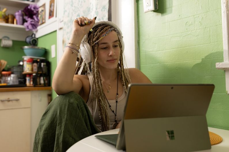 Student Discount - a woman with dreadlocks sitting in front of a laptop computer