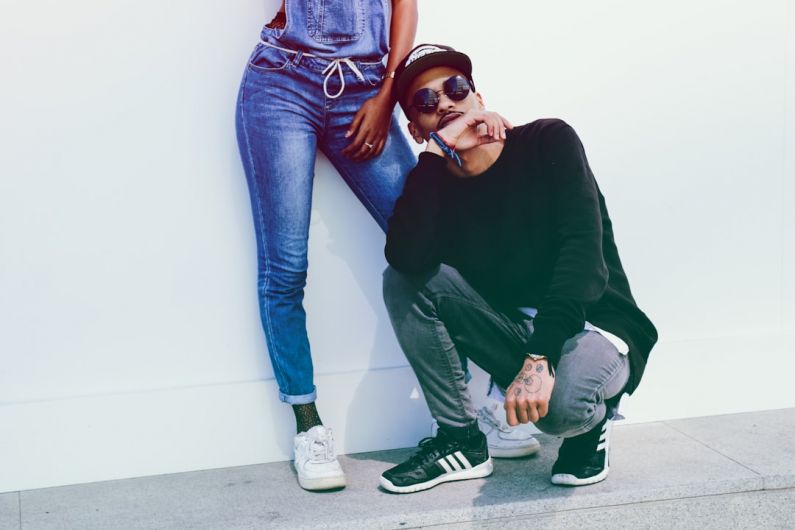 Denim Fashion - man sitting beside person wearing overalls